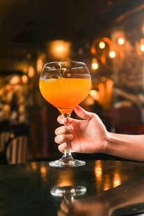 手持橙黄鸡尾酒特写