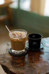 木桌上的冰咖啡与小杯