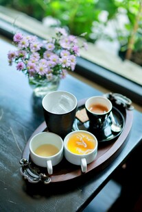 窗边精致茶饮与花卉摆件