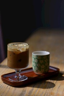木桌上的咖啡与中式茶杯