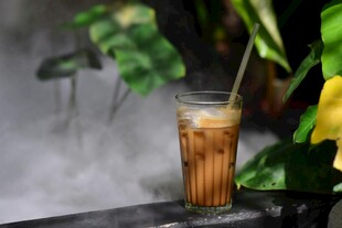 冰咖啡置于绿植旁烟雾中