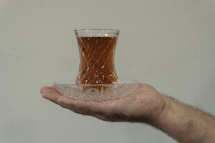 手托玻璃杯中棕色液体