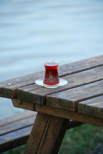 湖畔木桌上的红色土耳其茶杯