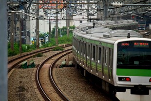 城市铁轨上行驶的绿色列车