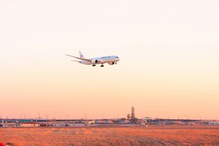 夕阳下飞机低空飞过机场