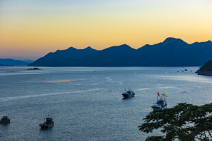 海上暮色中渔船与远山