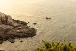 海边礁石与海上小船景象