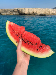手捧西瓜赏碧海美景