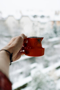 手持红杯赏窗外雪景