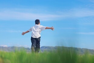 漫步草地的男子张开双臂