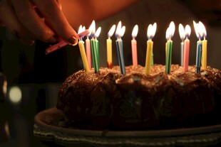 点燃生日蛋糕上的彩色蜡烛
