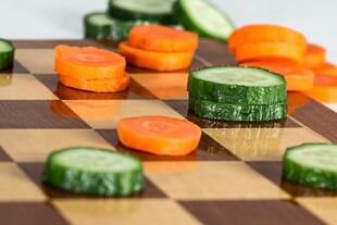 棋盘上的黄瓜胡萝卜切片蔬菜图片