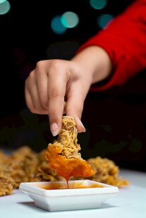 手蘸酱拿美味炸鸡块