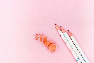 粉色背景的彩色铅笔及笔屑