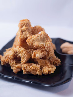 美味炸鸡块摆于黑色盘上