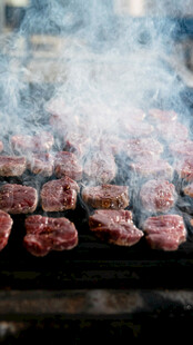 烤架上滋滋冒热气的牛肉