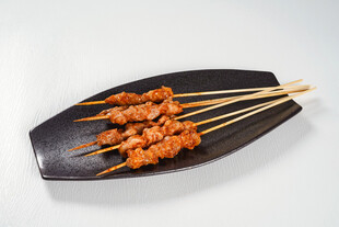 美味鸡肉串摆于黑色盘上