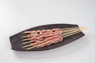 美味猪肉串置于黑色盘上