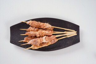 美味鸡肉串摆放在黑盘上
