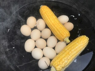 锅中煮鸡蛋与玉米