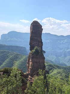 奇峰屹立于青山绿野间