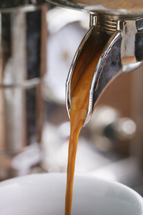 咖啡正从壶嘴流入白杯