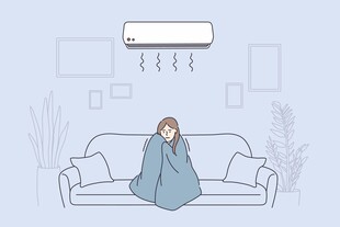 裹毯沙发上的人吹着空调