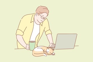 男子桌边与猫相伴用电脑