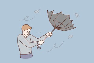男子奋力抵抗强风中的雨伞