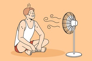 男子坐地吹风扇消暑