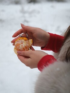 雪地中双手剥橘子画面