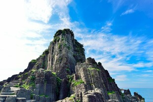巍峨奇峰屹立蓝天白云间