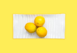 三颗鲜黄柠檬摆于木面