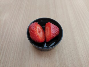 黑碟中两半新鲜草莓