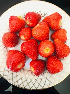 新鲜草莓摆放在白色盘中