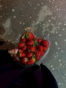 手捧心形盒中的新鲜草莓