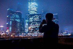 夜晚城市前的摄影者剪影