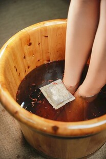 双脚浸于木盆中药水之中