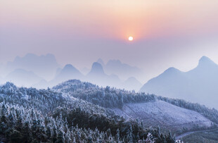 雪覆山峦间的壮丽日出