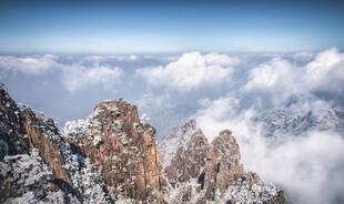 雪覆山峦云海间壮丽景观