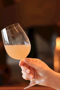 手持浅粉葡萄酒杯特写