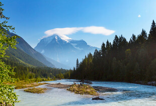 山间溪流旁的壮丽雪山景色