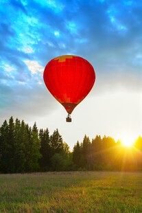 夕阳下的红色热气球升空