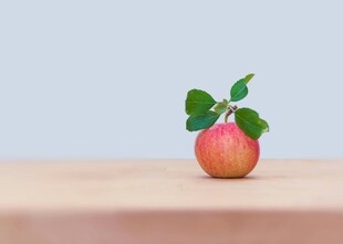 木桌上的带叶鲜苹果
