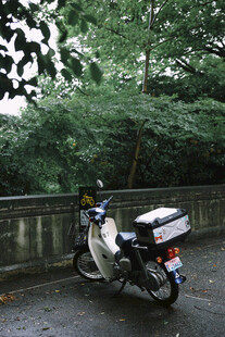 雨中停放的带箱白色摩托车