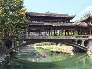 古风廊桥横跨碧绿水畔