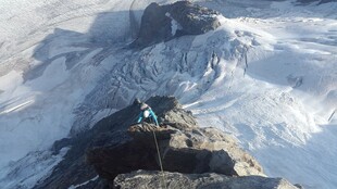 攀登者于雪山峭壁奋力攀爬