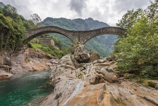 山间石拱桥下的碧绿溪流
