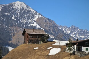 山间小屋背靠巍峨雪山