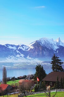 湖畔山村远处雪山美景